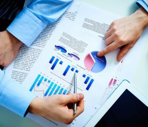 Close-up of female and male hands pointing at business document while discussing it